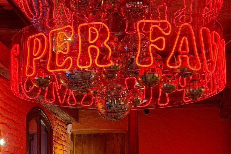 Detalles del techo con neón Per Favore y bolas de espejo en la pizzería italiana Ditaly de Jerez, ambiente desenfadado para cenar