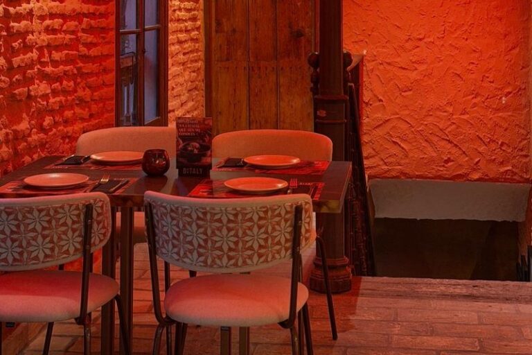Mesa con luz cálida lista disfrutar de una auténtica pasta italiana para cenar en Ditaly Jerez, entre ladrillo visto y escalera de época