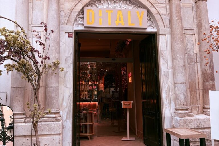 Fachada de Ditaly, restaurante italiano en el centro de Cádiz, con su entrada de mármol y el rótulo bajo un arco de piedra.