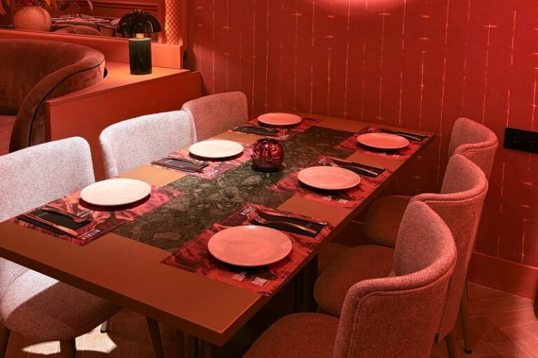 Mesa vestida para cenar italiano en Ditaly, en pleno centro de Cádiz, con vajilla artesanal sobre tablero de mármol verde.