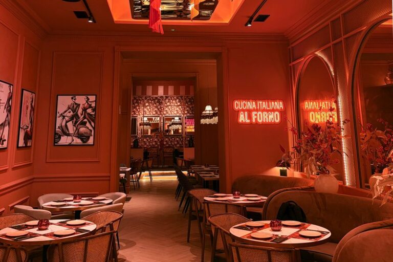 Sala principal de Ditaly bajo el neón «Cucina Italiana al Forno», para disfrutar de la gastronomía italiana en el centro de Cádiz.