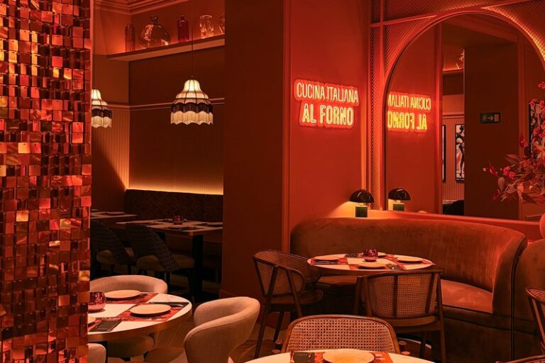 Rincón de mesas de Ditaly con pared de lentejuelas y lámparas de flecos, perfecto para cenar pasta italiana en el centro de Cádiz.