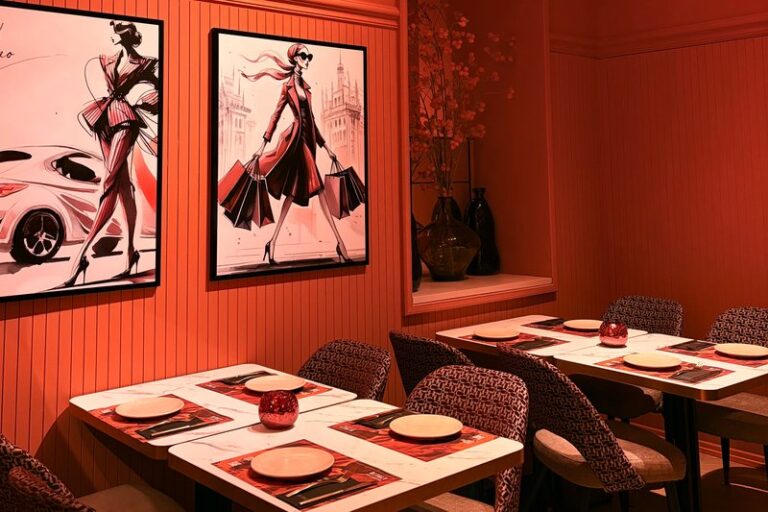 Mesas de mármol junto a ilustraciones de moda italiana en Ditaly, un plan ideal para comer pasta italiana en el centro de Cádiz.