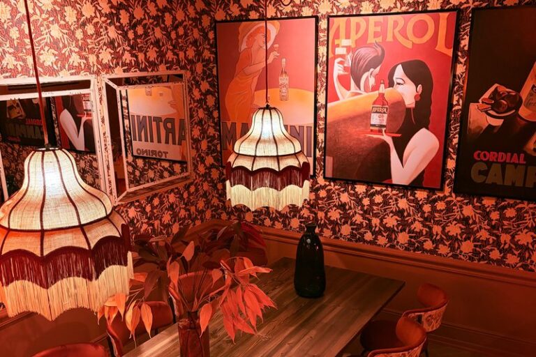 Reservado de Ditaly con carteles vintage de aperitivo italiano, un ambiente único para comer italiano en el centro de Cádiz.