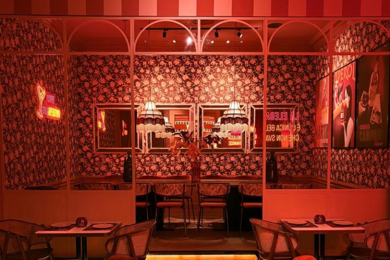 Reservado de Ditaly con papel pintado floral y carteles clásicos donde saborear auténtica pizza italiana en el centro de Cádiz.